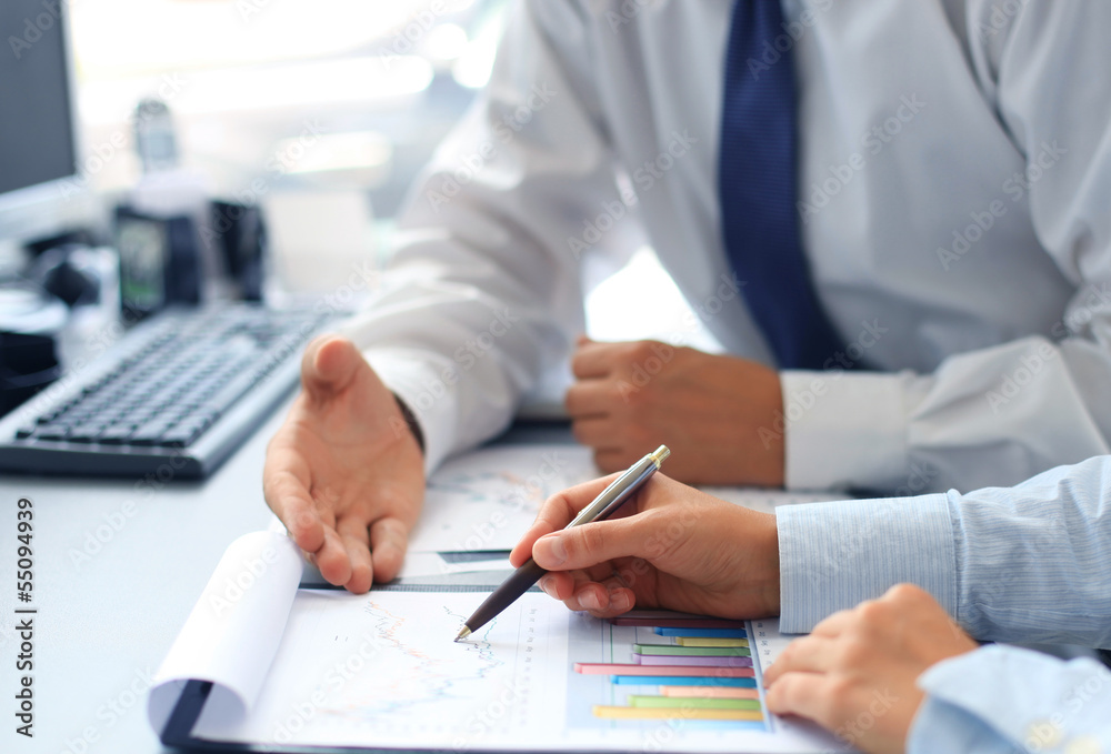 Unrecognizable business person analyzing graphs Unrecognizable business person analyzing graphs