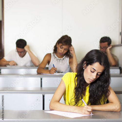 Schöne junge Studentin schreibt eine Prüfung