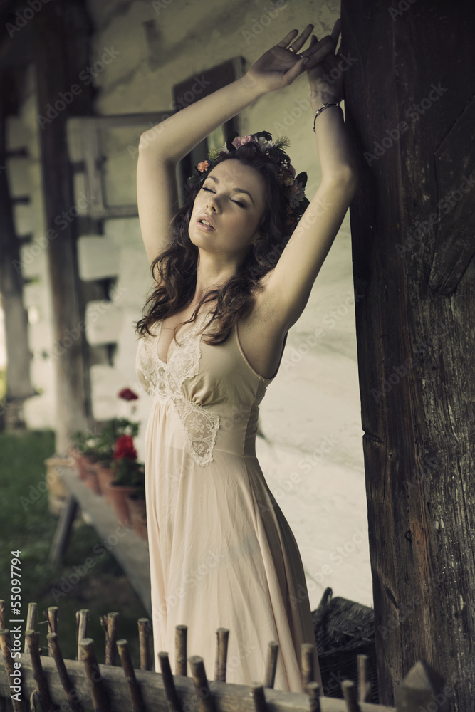 Sensual sexy woman posing next to the wooden house