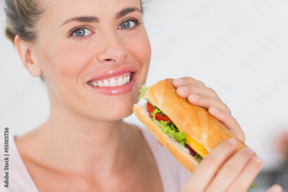 Cheerful woman holding sandwich