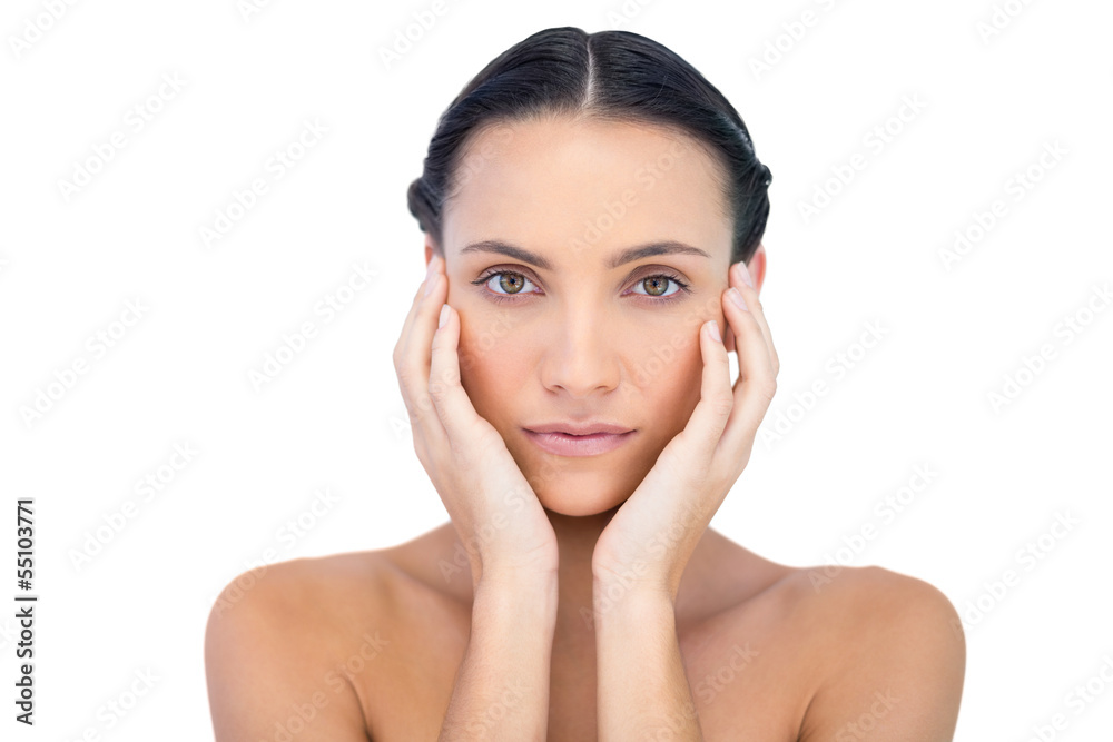 Young attractive model with hands on face looking at camera