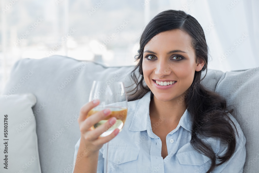 Seductive brunette drinking white wine on sofa Seductive brunette drinking white wine on sofa