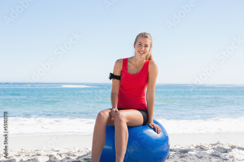 Fit young blonde sitting on exercise ball