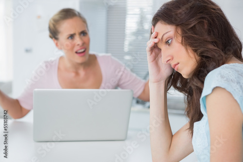 Unhappy woman thinking while her friend is interrogating her