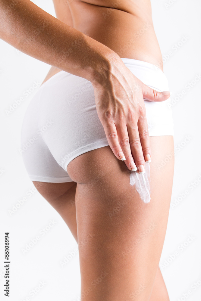 Woman applying cream on legs - obrazy, fototapety, plakaty 