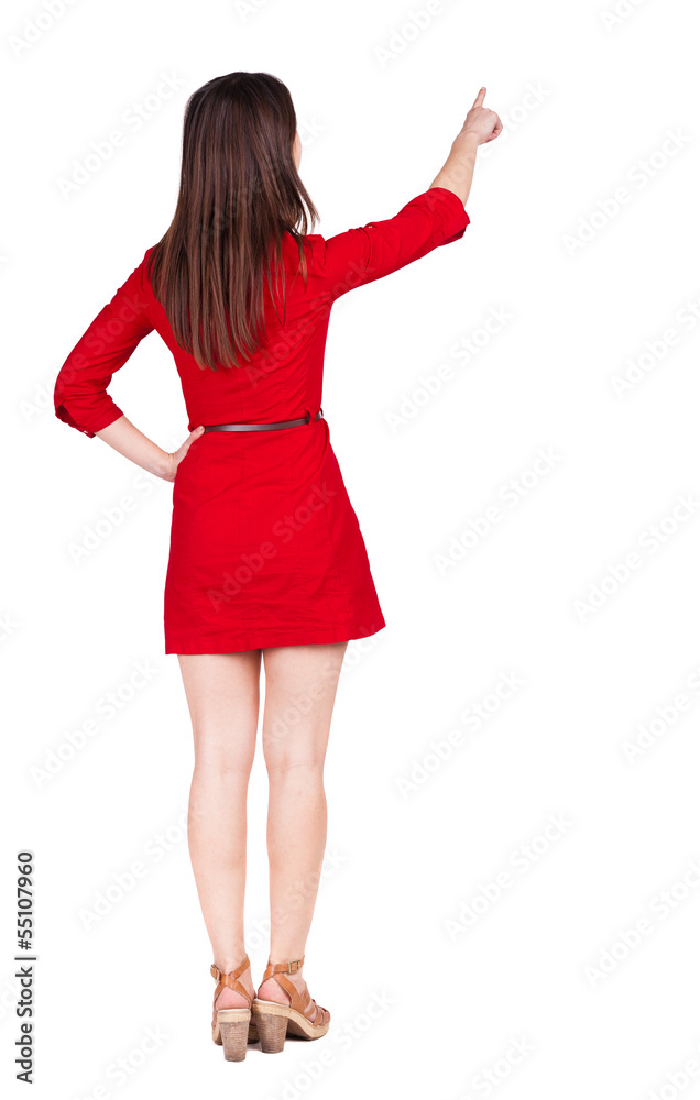 Back view of young brunette woman pointing at wall. Back view of young brunette woman pointing at wall.