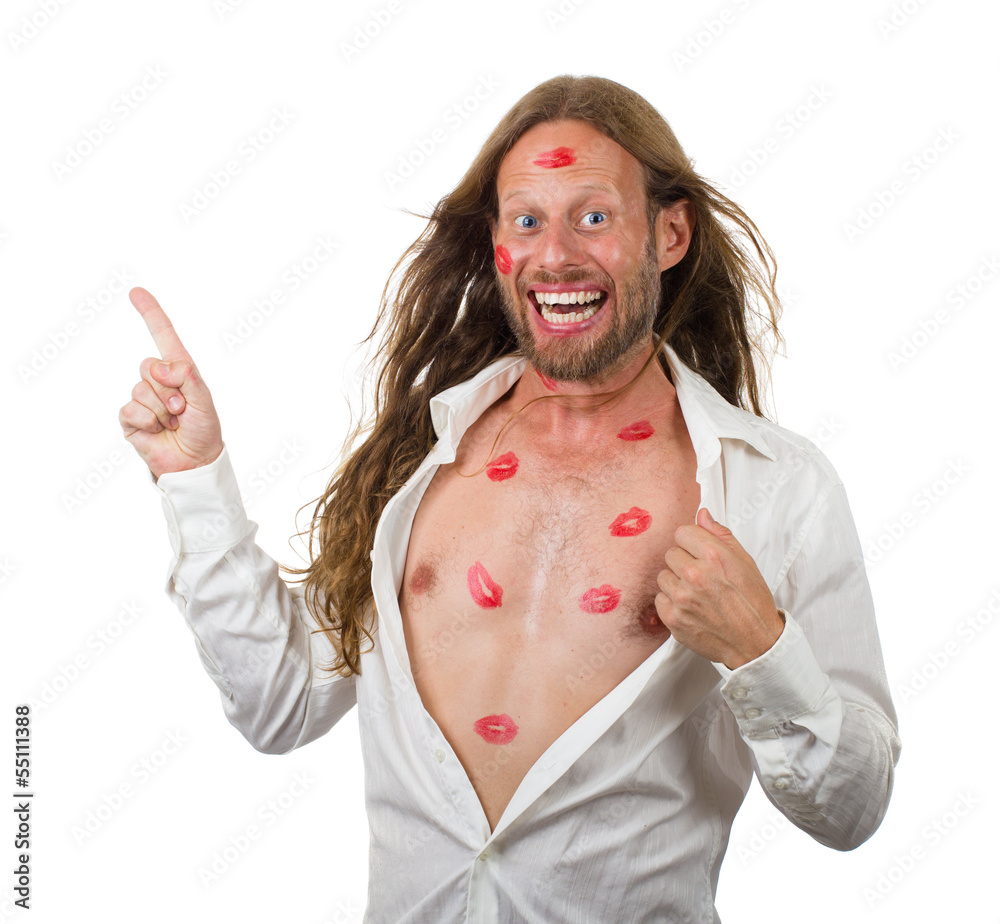 Foto Stock Funny man covered in lipstick kisses pointing at copy-space on w  | Adobe Stock