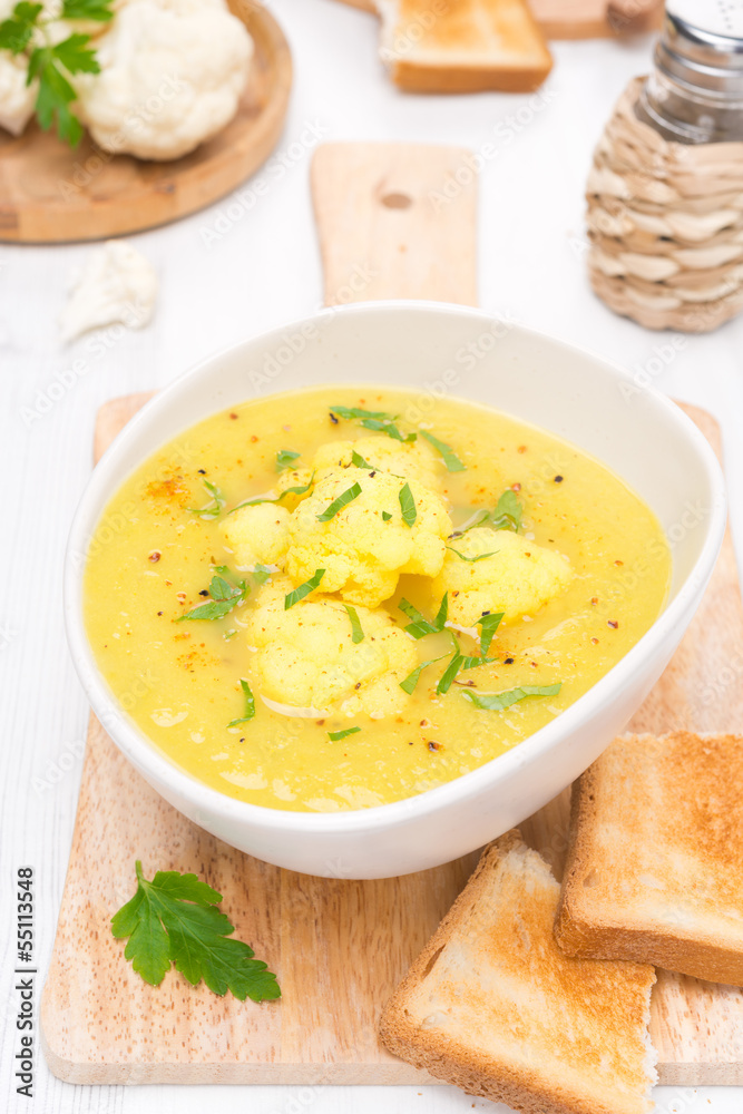 cauliflower soup with curry in a bowl and toast