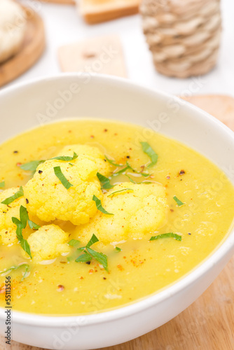 cauliflower soup with curry in a white bowl, close-up