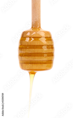 Honey dripping from a wooden dipper