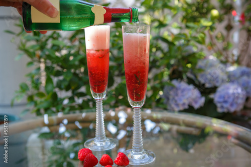 Summer cocktail with champagne and fresh raspberries photo