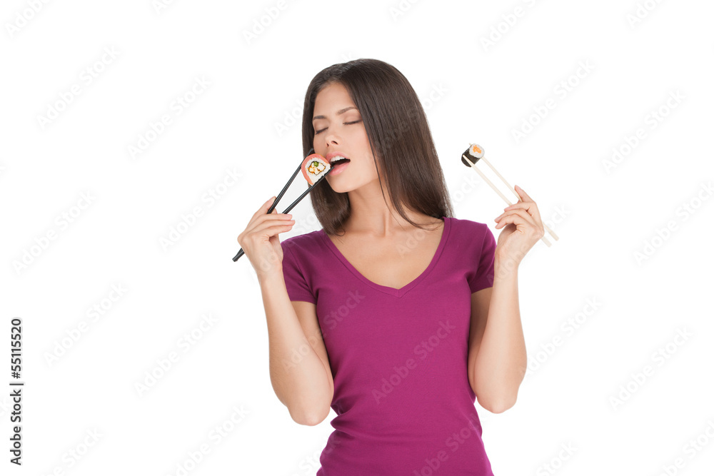 Woman eating sushi. Beautiful mixed race woman holding sushi by Woman eating sushi. Beautiful mixed race woman holding sushi by