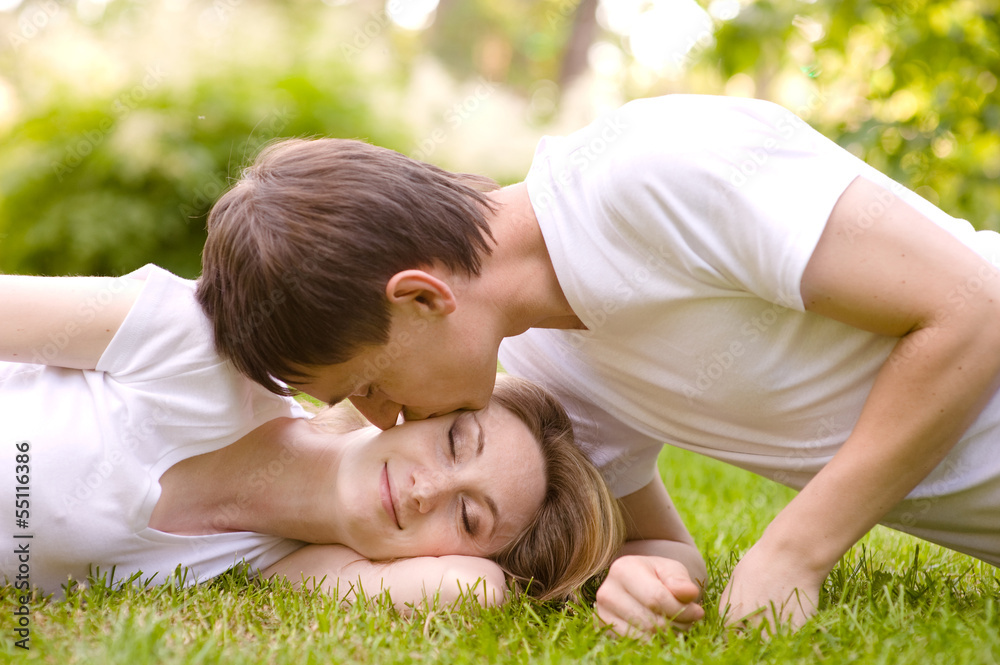 young couple lying head to head on the grass young couple lying head to head on the grass