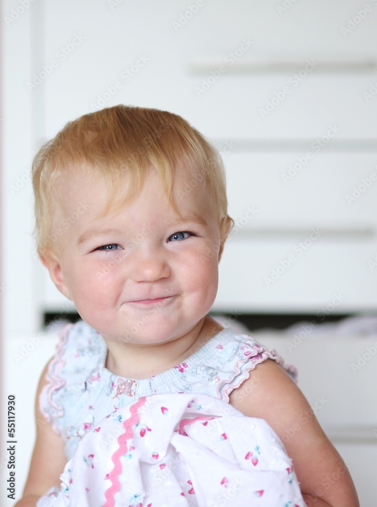 Funny smiling little girl in dress in front of white commode Funny smiling little girl in dress in front of white commode