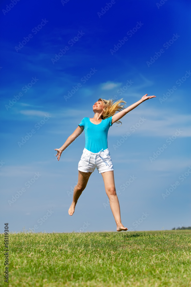 happy woman jumps in a summer green field against blue sky... happy woman jumps in a summer green field against blue sky...