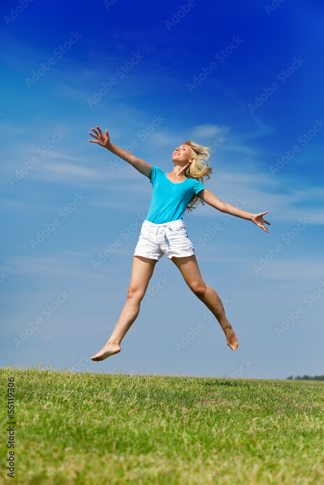 happy woman jumps in a summer green field against blue sky... happy woman jumps in a summer green field against blue sky...