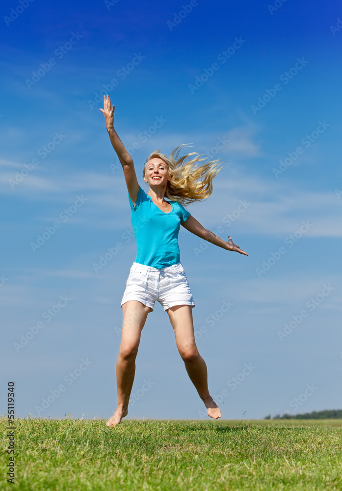 woman jumps in a summer green field against the blue sky... woman jumps in a summer green field against the blue sky...