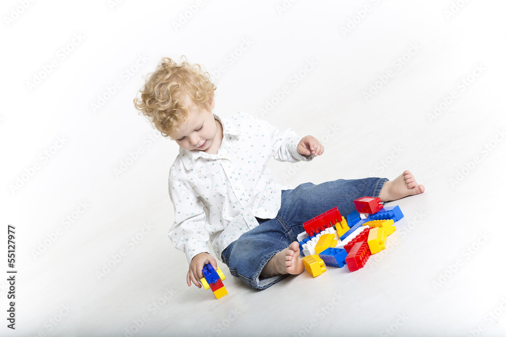 Toddler is building with blockss on the floor Toddler is building with blockss on the floor