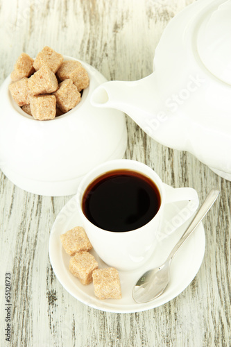Fototapeta Naklejka Na Ścianę i Meble -  Cup of coffee, teapot and sugar-bowl on color wooden background