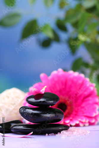 Spa stones and beautiful gerbera on wooden table