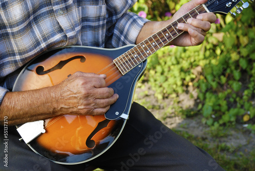 Senior man playing mandolin photo