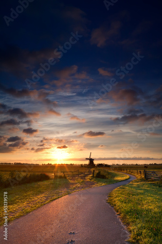 warm summer sunrise and windmill