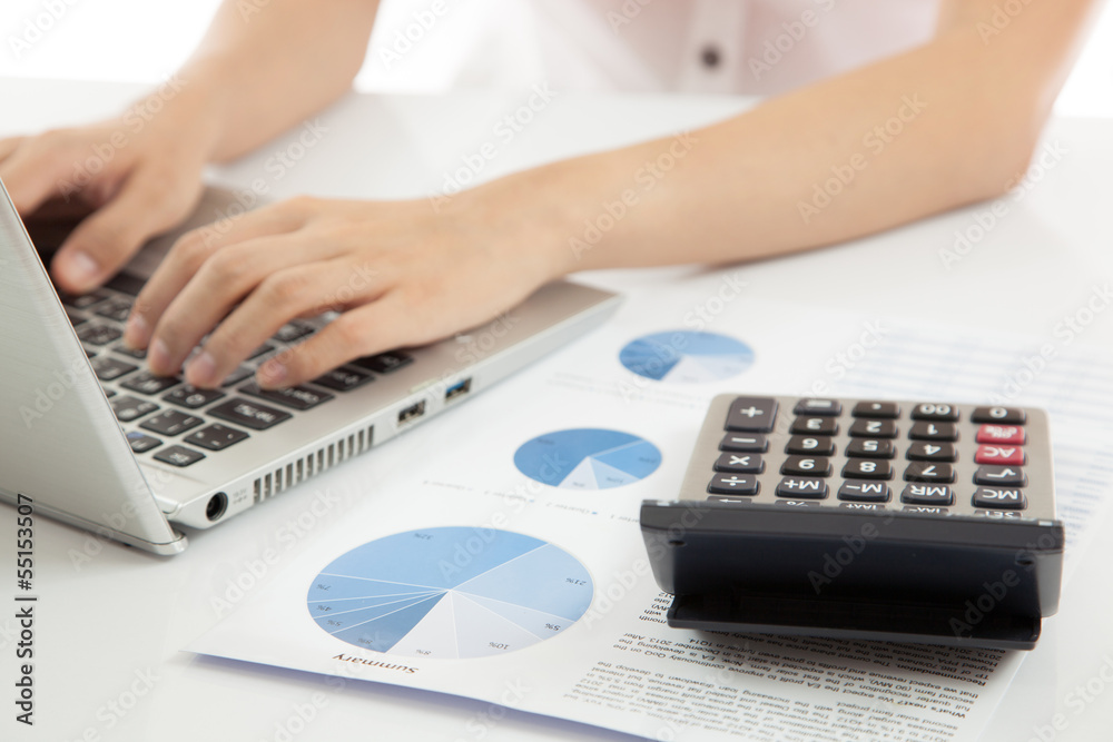 woman hand on laptop with business report woman hand on laptop with business report