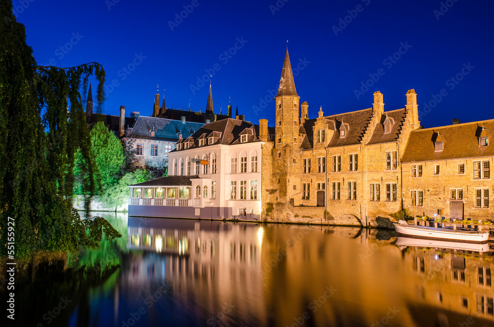 Bruges canal at night and medieval houses with reflection in wat