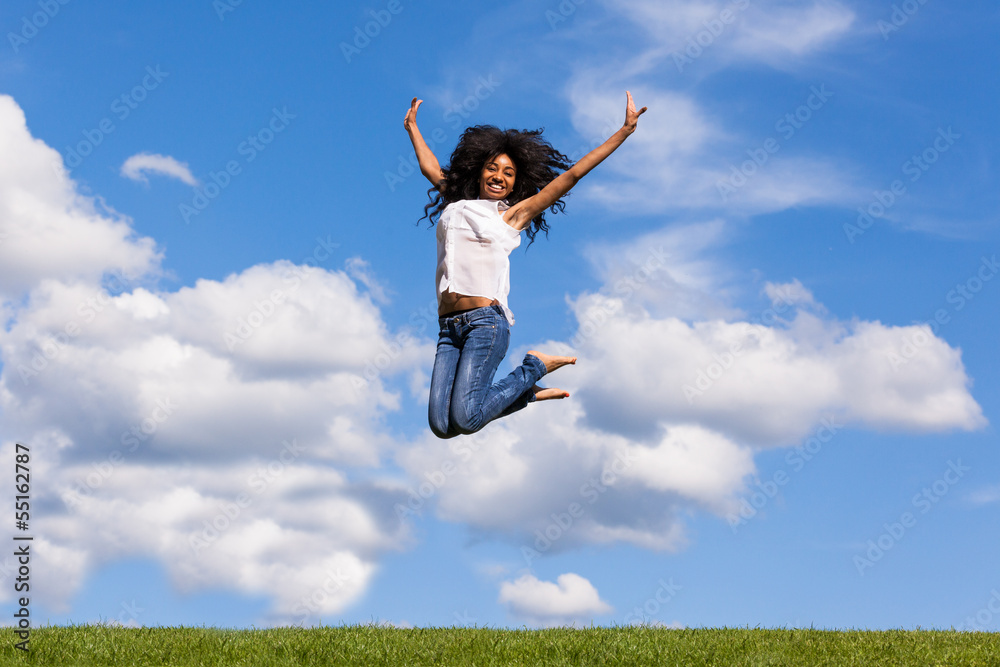 Outdoor portrait of a teenage black girl jumping over a blue sky Outdoor portrait of a teenage black girl jumping over a blue sky