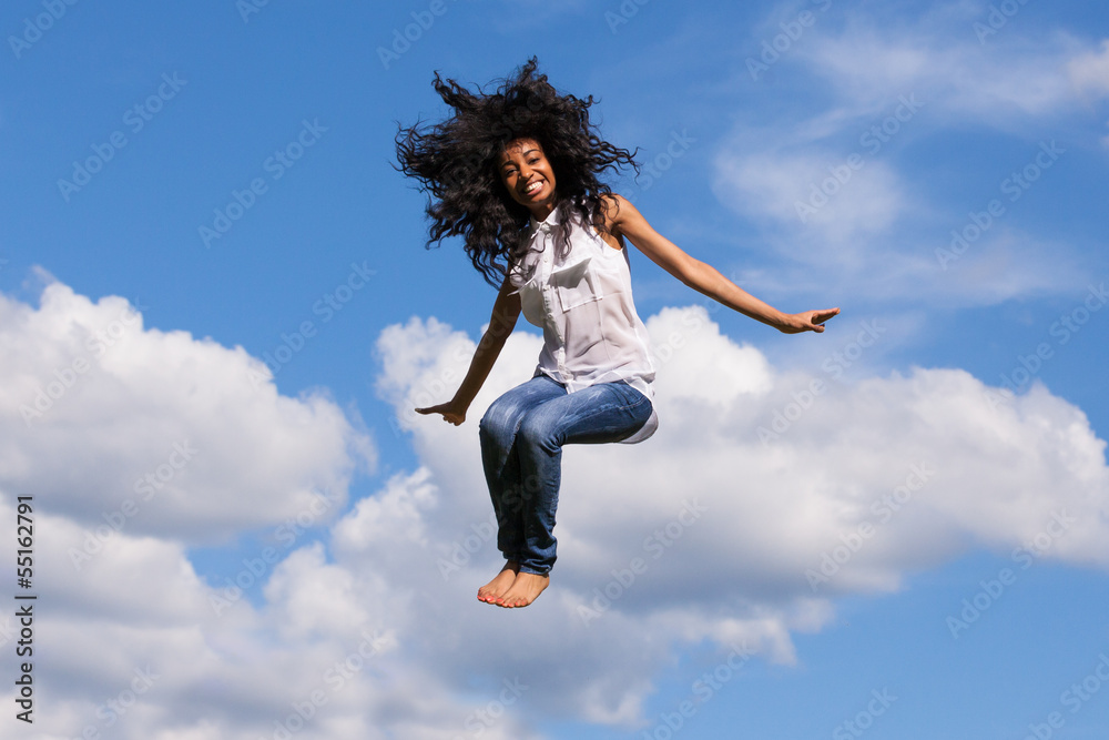 Outdoor portrait of a teenage black girl jumping over a blue sky Outdoor portrait of a teenage black girl jumping over a blue sky