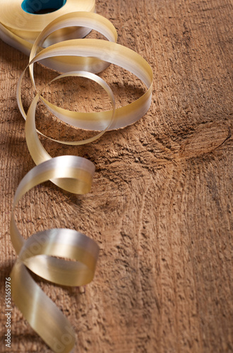 Gold ribbons on wooden background