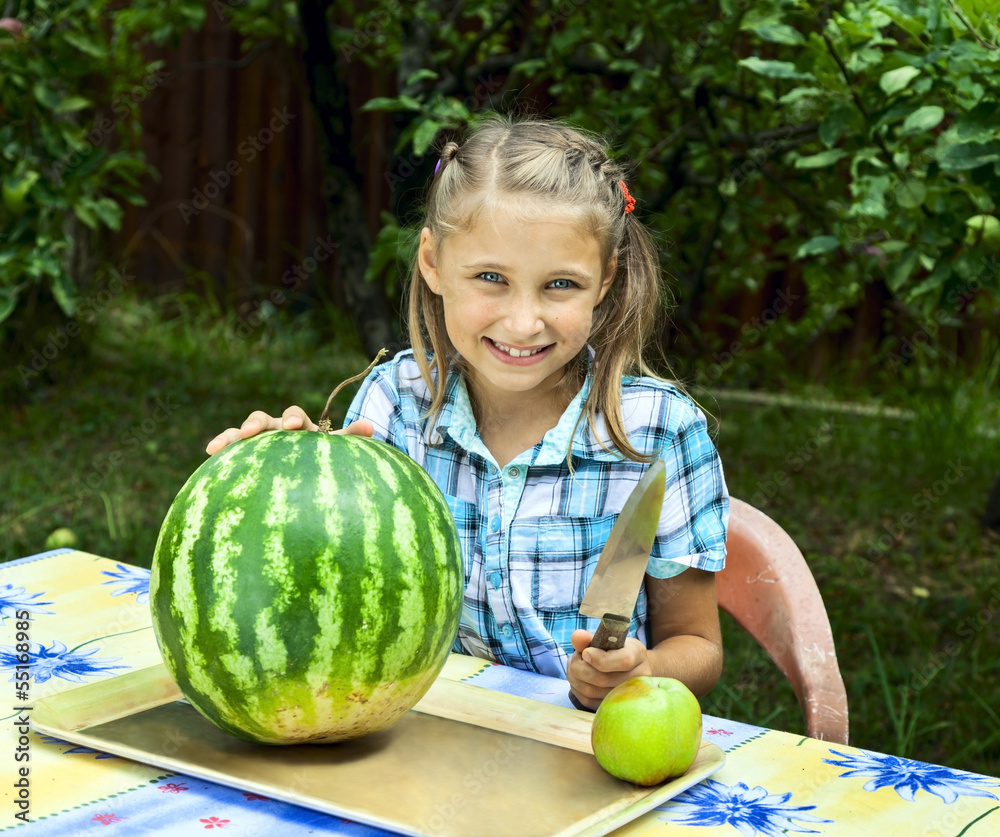 Fototapeta premium Young girl cut ripe watermelon