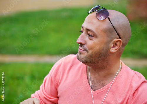 Handsome man wearing pink pullover   have rest outdoor