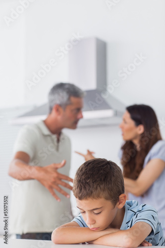 Couple having dispute in front of their sad son