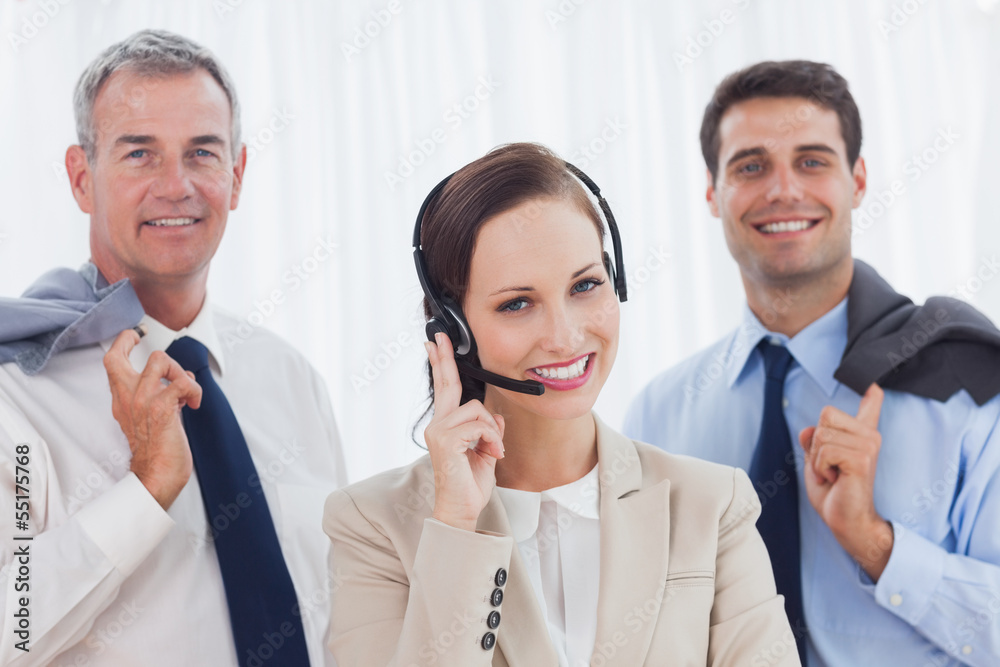 Smiling call center agent posing with her work team Smiling call center agent posing with her work team