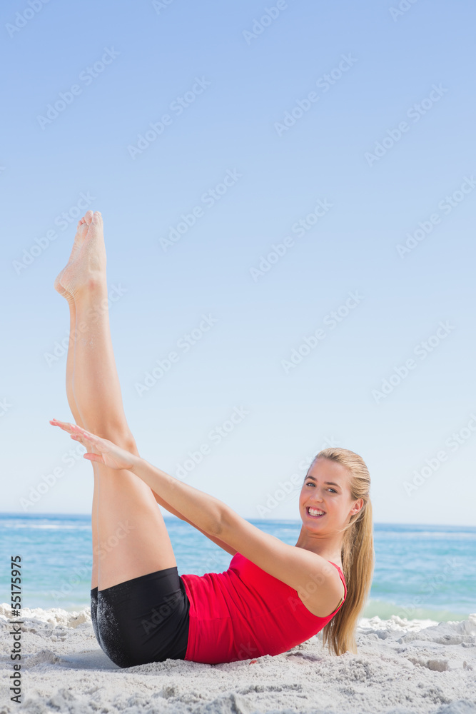 Athletic blonde doing pilates core exercise smiling at camera Athletic blonde doing pilates core exercise smiling at camera
