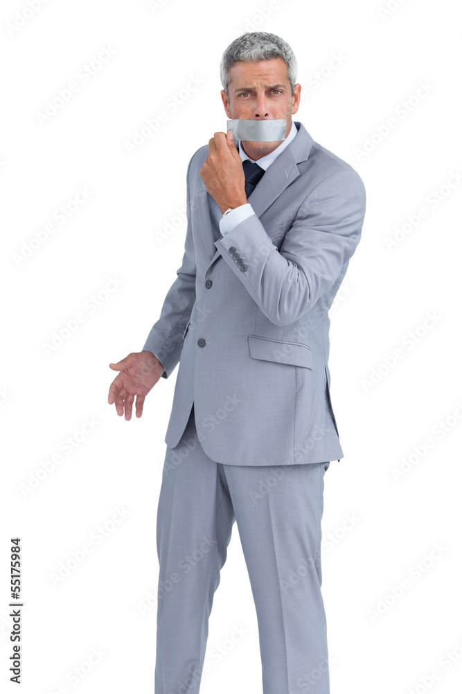 Businessman taking off adhesive tape on mouth Businessman taking off adhesive tape on mouth