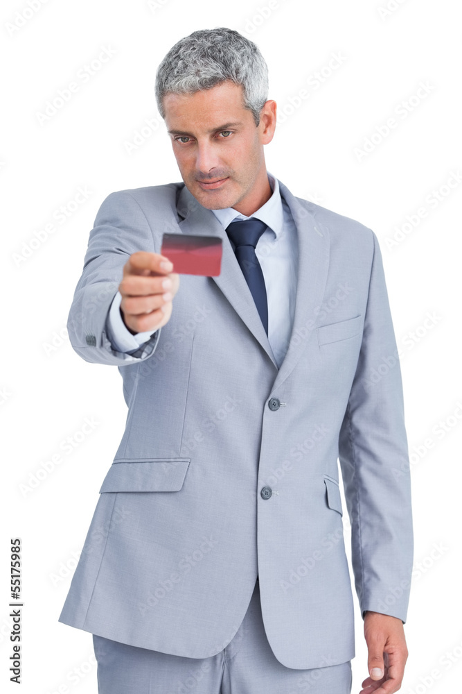 Handsome businessman holding and looking at credit card Handsome businessman holding and looking at credit card