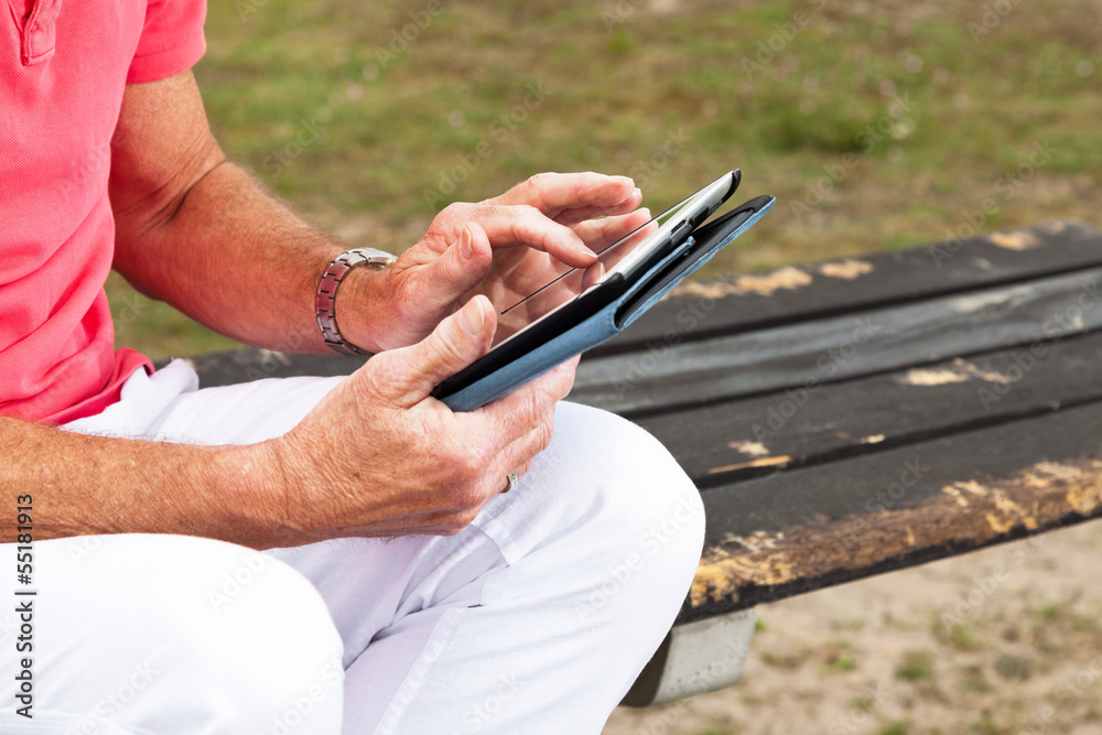 Close-up of hands of retired senior man resting and using his ta Close-up of hands of retired senior man resting and using his ta