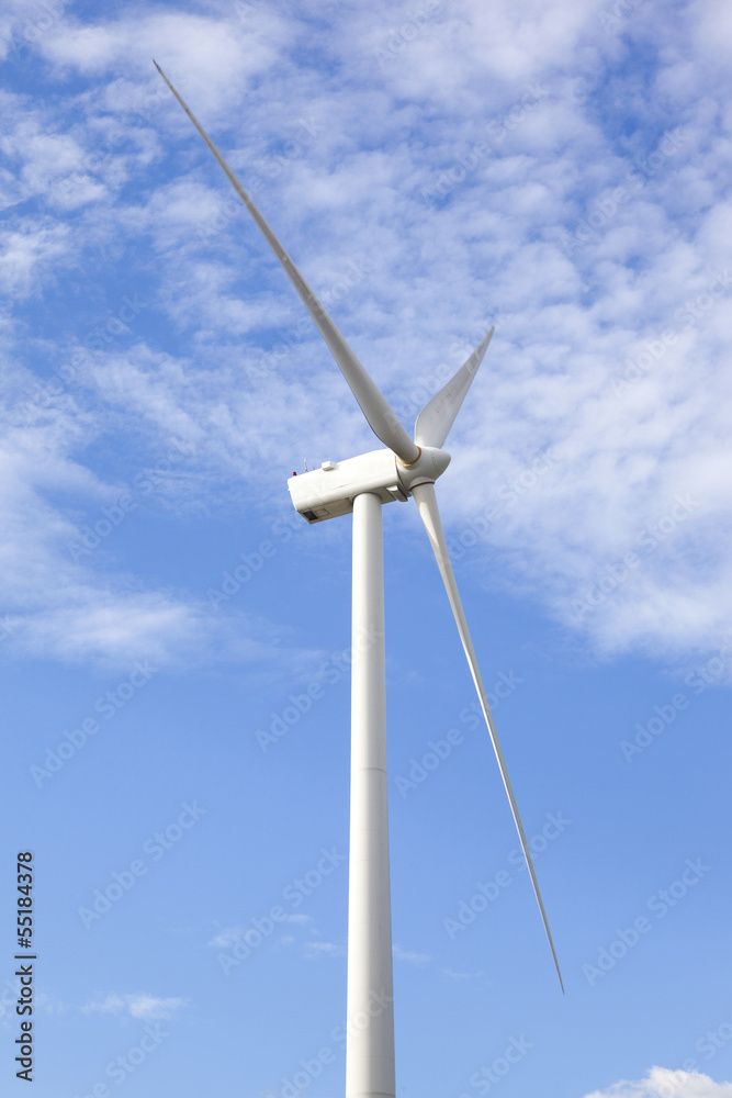 Wind turbine against cloudy blue sky Wind turbine against cloudy blue sky