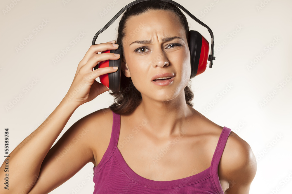Naklejka premium young brunette can not hear because of the anti loud headset