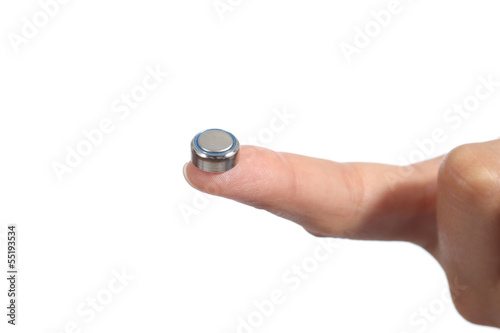 Woman hand holding a button battery with the forefinger