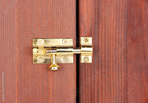 Metal latch in wooden door close-up