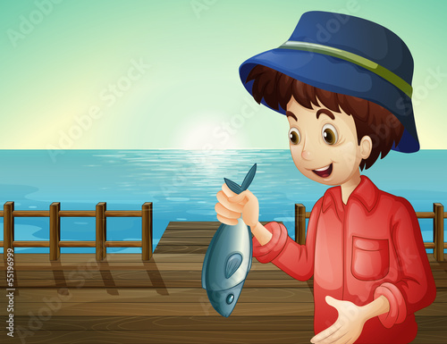 A fisherman holding a fish at the seaport