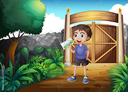 A boy holding a picture inside the gate