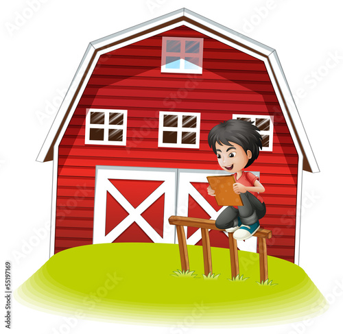 A teenager reading near the barnhouse