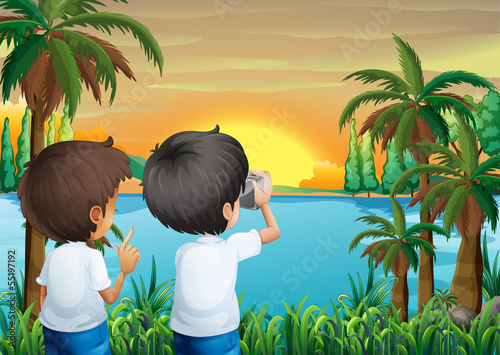Two kids with a camera at the riverbank