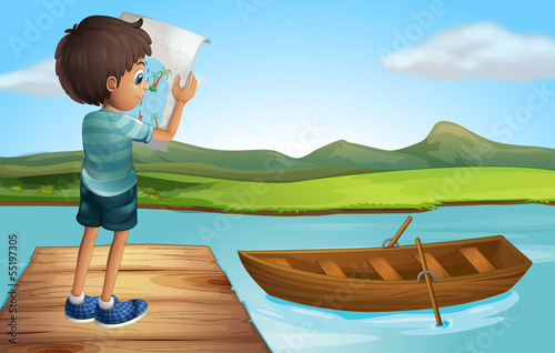 A boy at the river with a wooden boat