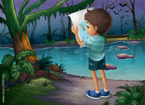 A boy with a map standing in the middle of the forest