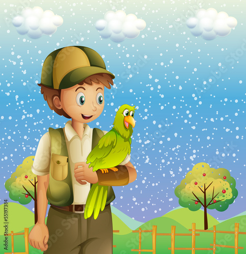 A boy holding a green parrot